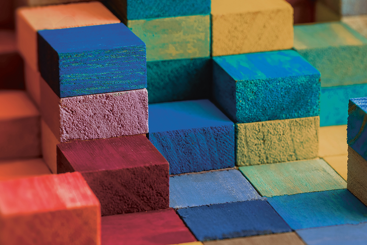 Spectrum of stacked multi-colored wooden blocks. Background or cover for something creative, diverse, expanding, rising or growing.